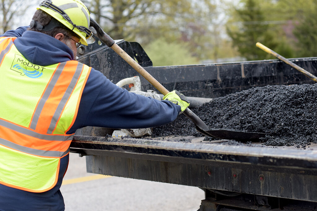 Justin Kumberg shovels pot hole filler